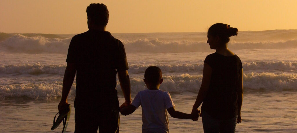 Familie am Strand bei Sonnenuntergang
